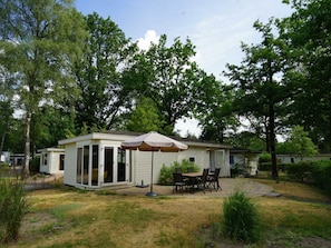A mobile home with a patio area, including a table and chairs, and a covered seating area. - Holiday Home in Arnhem With Terrace (Arnhem)