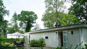 A single-story building with a patio area, a table with chairs, and a covered seating area. - Holiday Home in Arnhem With Terrace (Arnhem)