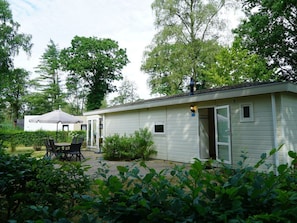 A single-story building with a patio area, a table with chairs, and a covered seating area. - Holiday Home in Arnhem With Terrace (Arnhem)