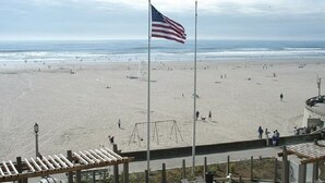 Ein Strand mit amerikanischer Flagge, einem Spielplatz und einer Promenadenlaufbahn.