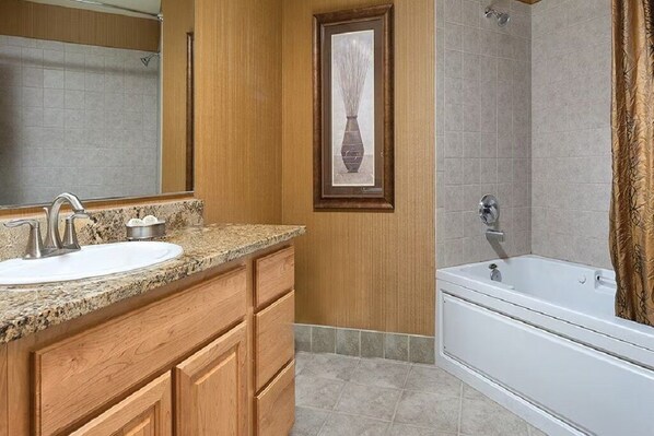 A bathroom with a sink, vanity, mirror, framed artwork, shower, and bathtub. - Cozy 1-bedroom resort in serene Seaside with ocean front view great Fireworks (Seaside)