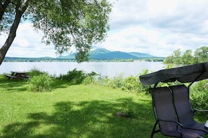Ein Campingplatz am Seeufer mit Picknicktisch und Stuhl.