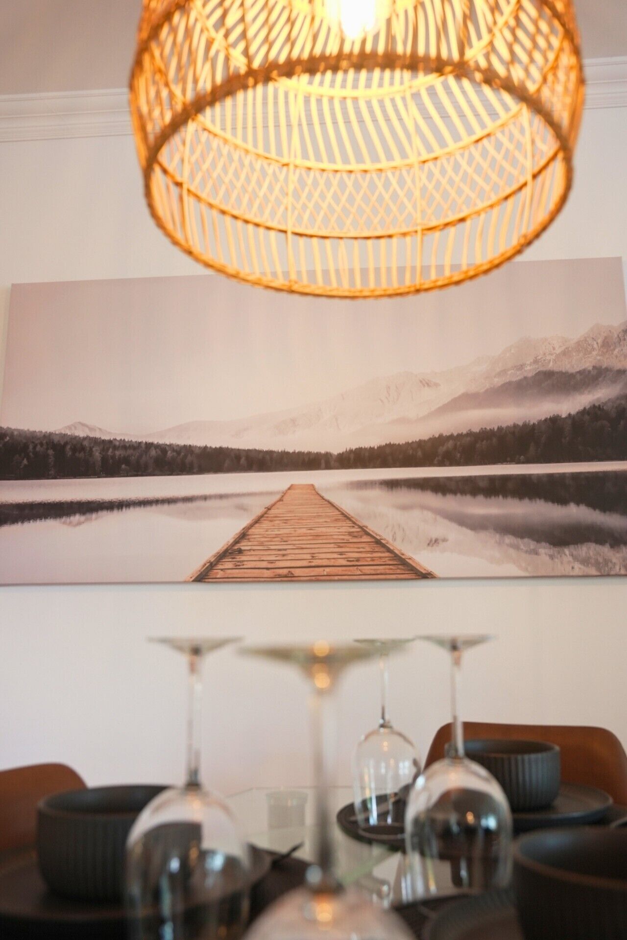 A dining area with a table, chairs, and a hanging light fixture.