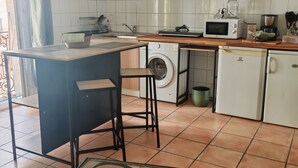 A kitchen with a washing machine, microwave, and a coffee maker. - A 35-square-meter studio in the heart of downtown, just a stone's throw from all the attractions. (Béziers)