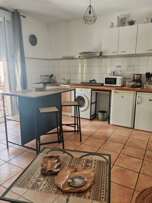 Eine Küche mit Waschmaschine, Mikrowelle und Kaffeemaschine.