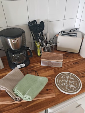 Eine Küche mit Kaffeemaschine, Toaster und Zucker.