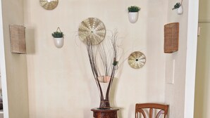 A room with a glass table, two chairs, a decorative vase, and wall-mounted planters. - A 35-square-meter studio in the heart of downtown, just a stone's throw from all the attractions. (Béziers)