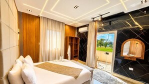 A modern hotel room with a large bed, a wardrobe, a mirror, and a view of the outdoors. - glow pyramid view (Giza)