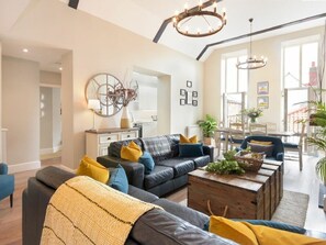 A modern living room with a sofa, coffee table, and decorative items. - Juniper Cottage (Seahouses)