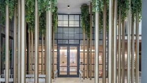 Eine moderne Lobby mit hohen Säulen, einem zentralen Eingang und Blick ins Innere des Gebäudes.