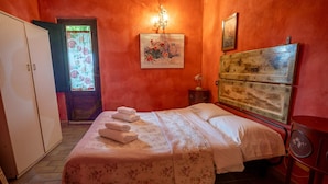 Une chambre à coucher avec un lit, une armoire, une table de chevet et un tableau au mur.
