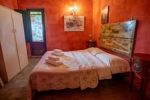 Ein Schlafzimmer mit Bett, Kleiderschrank, Nachttisch und einem Bild an der Wand.