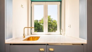 A kitchen with a window, a sink, and two cabinets.
