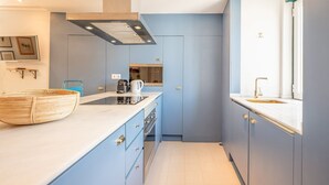 A compact kitchen with a built-in stove, a coffee maker, and a window with a view.