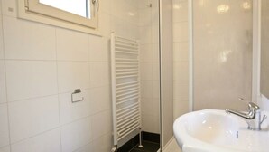 A bathroom with a toilet, a sink, a shower, and a window. - Unique Nouveau 4 (Otterlo)