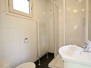 A bathroom with a toilet, a sink, a shower, and a window. - Unique Nouveau 4 (Otterlo)