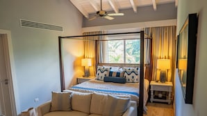 A bedroom with a four-poster bed, a sofa, bedside tables, and a ceiling fan. - Unique Penthouse with Huge Private Rooftop & Jacuzzi - Beach & Restaurant Nearby (El Limón)