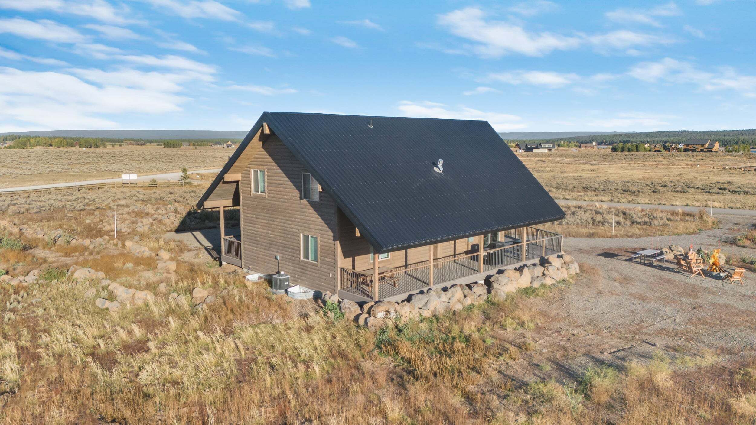 A cabin with a sloped roof, a porch, and a stone foundation.