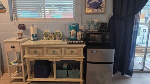 A compact kitchen with a refrigerator, microwave, and a coffee maker on the counter.