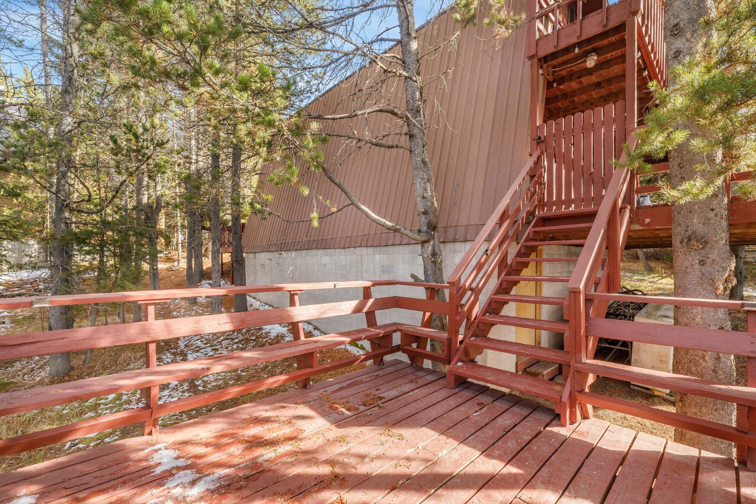 A wooden deck with a staircase leading to a building.
