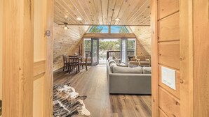 Un intérieur en bois avec un canapé, une table à manger et des chaises.