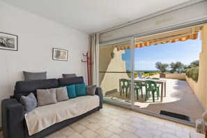 A balcony with a sofa, chairs, and a table. - Holiday Home “L'albatros Direct Beach Access 3” (Palavas-les-Flots)