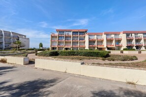 A multi-story hotel with balconies, a parking area, and landscaped gardens. - Holiday Home “L'albatros Direct Beach Access 3” (Palavas-les-Flots)