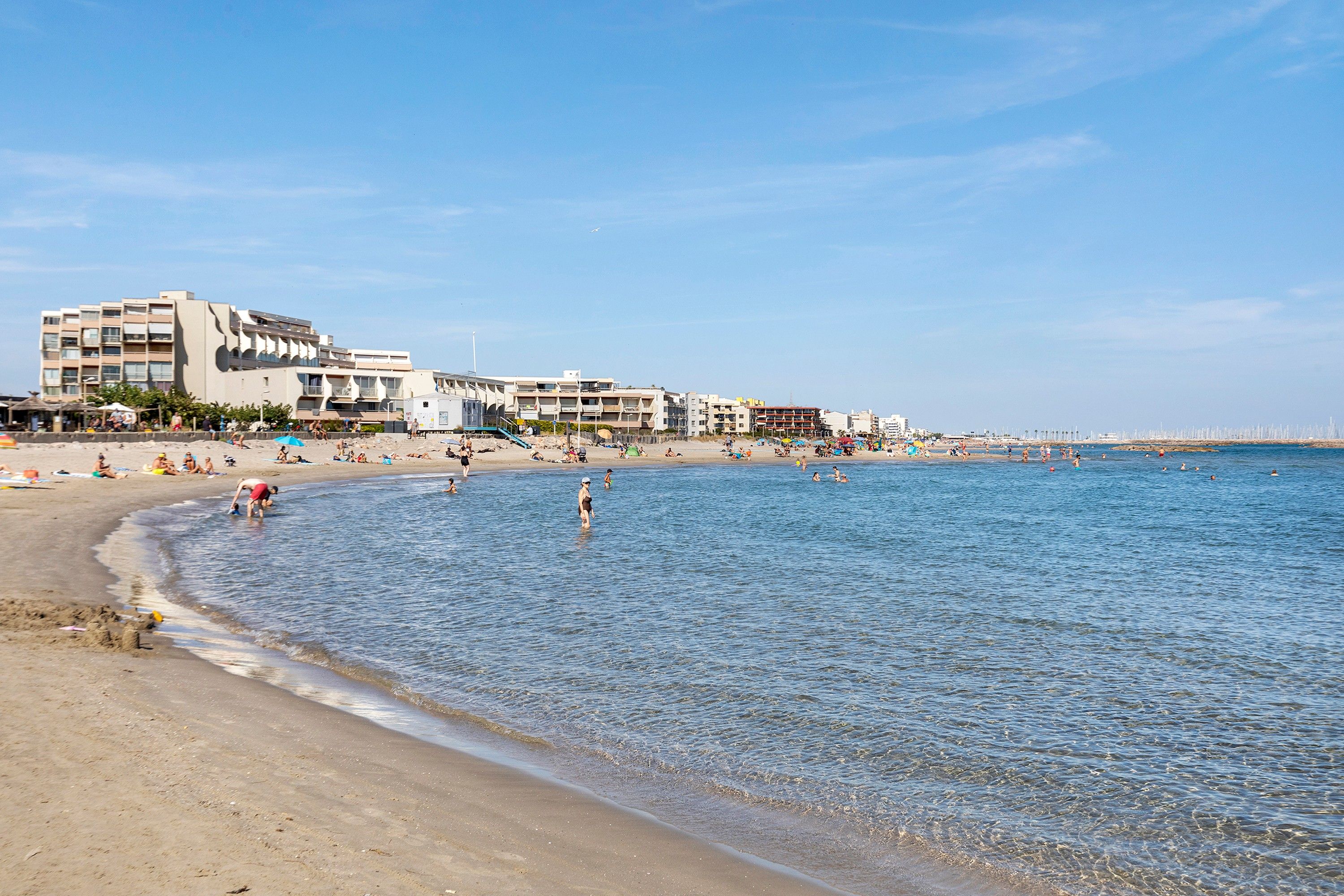 Una playa con una hilera de edificios a lo largo de la orilla.