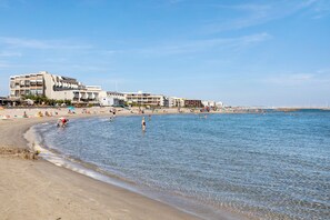 Una playa con una hilera de edificios a lo largo de la orilla.