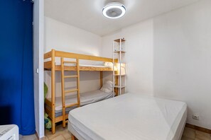 A bunk bed room with a white mattress, a wooden ladder, and a white shelf unit. - Holiday Home “L'albatros Direct Beach Access 3” (Palavas-les-Flots)