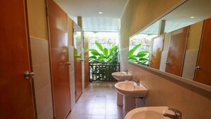 Ein Badezimmer mit Spiegel, zwei Waschbecken und Blick auf Grünfläche.