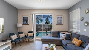 A modern living room with a sofa, chairs, a coffee table, and a TV. - Go!#32 CHAMPIONS GATE (Kissimmee)