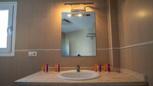 Ein Badezimmer mit Waschbecken, Spiegel und Pflegeprodukten.