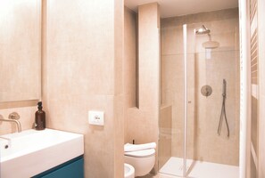 Une salle de bain moderne équipée d’une baignoire, de toilettes et d’un espace douche.