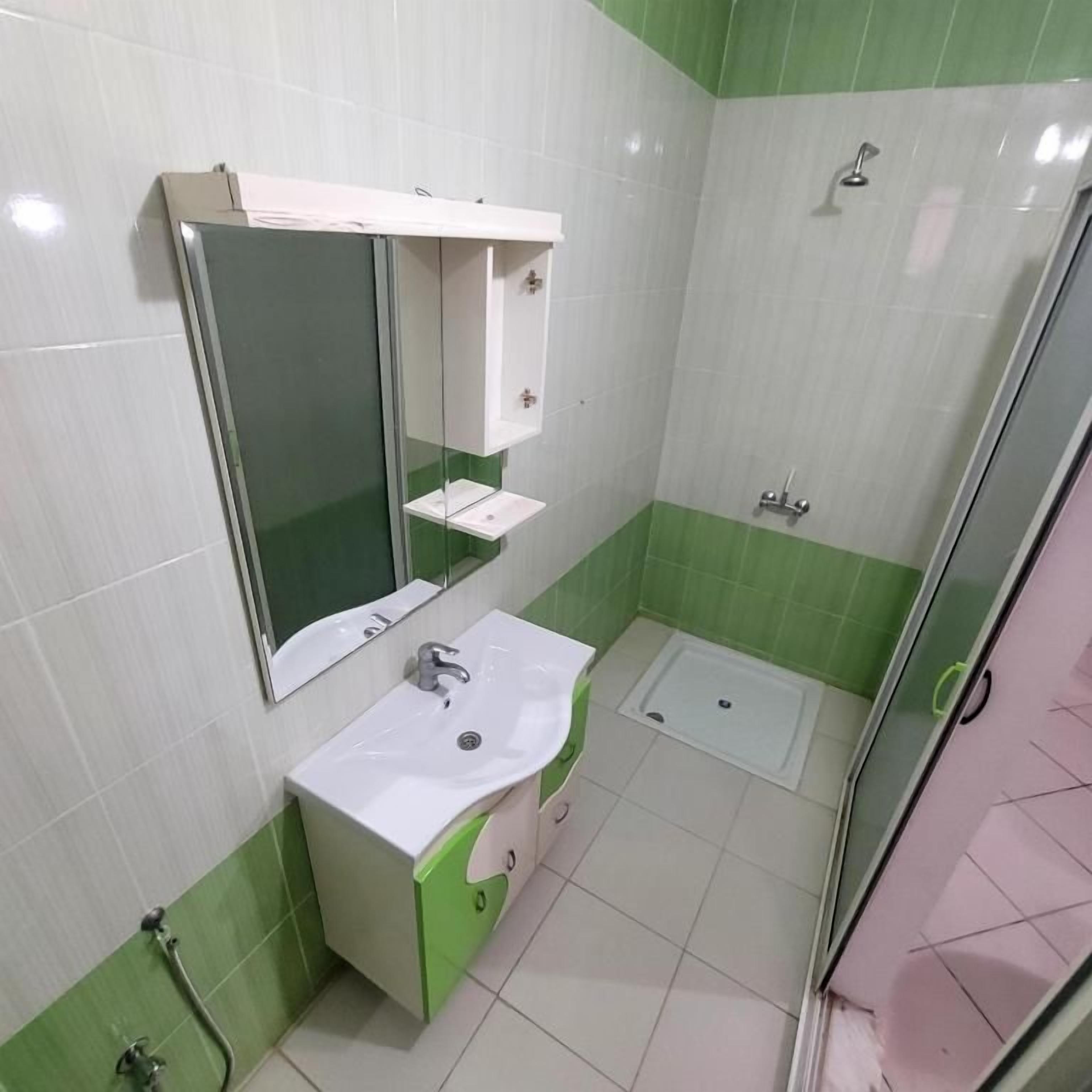 Un baño con lavamanos, espejo y ducha.