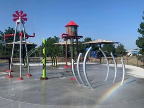 A playground with a water play area, including a windmill and a tower structure. - Spacious, Big Family-Friendly 4 Bedroom Ranch Home in Hays, Kansas (Hays)