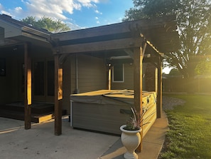 A covered outdoor area with a wooden structure, a bench, and a potted plant. - Spacious, Big Family-Friendly 4 Bedroom Ranch Home in Hays, Kansas (Hays)