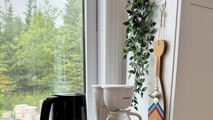 A kitchen with a microwave, a coffee maker, and a hanging plant.