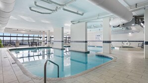 An indoor swimming pool with clear water, surrounded by tiled flooring and white pillars. - Phoenix 6 1111 (Orange Beach)