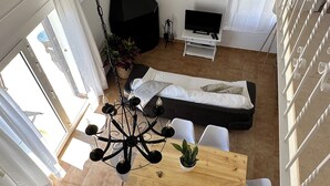 Un espace de vie moderne comprenant un coin repas, un canapé, un téléviseur et une cheminée.