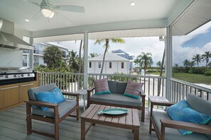 A covered outdoor area with a grill, seating, and a view of a residential building. - Renovated 4BD family beach retreat steps from the sandy beach of Bonita Springs (Bonita Springs)