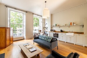 Eine moderne Küche mit weißen Schränken, einer Holz Arbeitsplatte und einer Pendelleuchte.