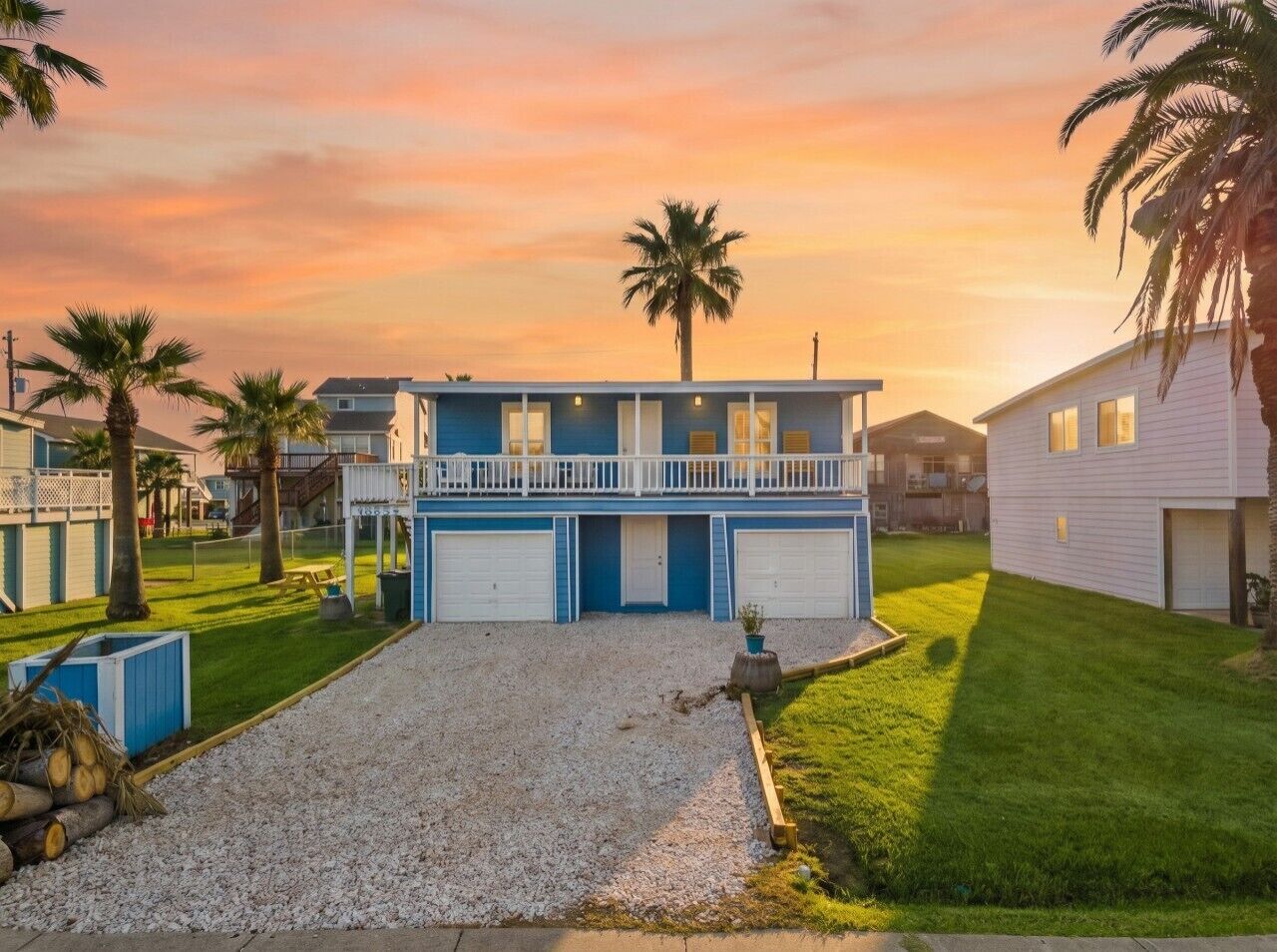 A two-story house with a balcony, a garage, and a well-maintained lawn.