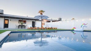 A swimming pool with lounge chairs and a unicorn float.