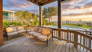 Una terraza de madera con un sofá y una piscina.