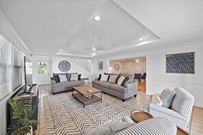 Un salon moderne comprenant un canapé, une table basse et un tapis à motifs.