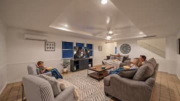 A living room with a sofa, chairs, a coffee table, and a TV.