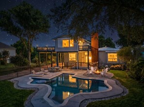 Une maison avec une piscine, un espace extérieur aménagé pour s’asseoir et une terrasse couverte.