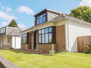 A two-story house with a large bay window, a pitched roof, and a well-maintained lawn. - Sundale (Strathaven)