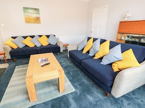 A living room with two sofas, a coffee table, and a painting on the wall. - Sundale (Strathaven)